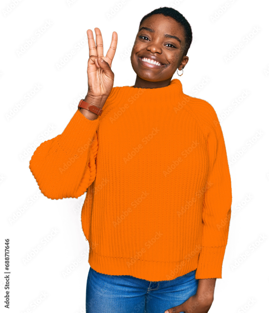 Wall mural Young african american woman wearing casual clothes showing and pointing up with fingers number three while smiling confident and happy.