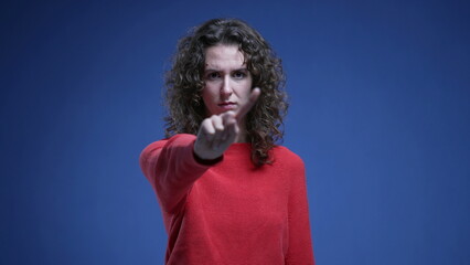 Young woman waving finger saying NO to camera refusing behavior, asserting boundary