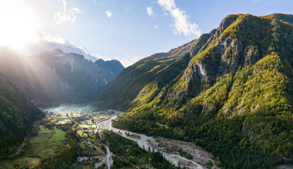 Aerial Panorama over Theth Village in the Northern Albanian Alps with Beautiful Sunbeams - obrazy, fototapety, plakaty