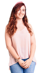 Obraz premium Young beautiful woman wearing casual clothes and diadem looking positive and happy standing and smiling with a confident smile showing teeth