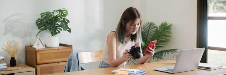 Creative designer woman checking photo on smartphone and working graphic design in home studio..