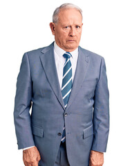 Senior handsome grey-haired man wearing elegant suit skeptic and nervous, frowning upset because of...