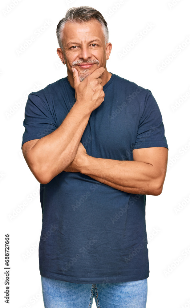 Canvas Prints Middle age grey-haired man wearing casual clothes looking confident at the camera smiling with crossed arms and hand raised on chin. thinking positive.