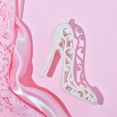 Christmas decoration, women's shoe, pink satin and lace drapery background, New Year celebration party.