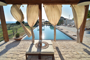 Piscina con gazebo e arredamento con divani e lettini
