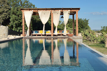 Piscina con gazebo e arredamento con divani e lettini