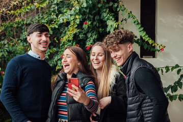Smiling friends browsing mobile phone