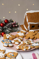 Christmas gingerbread in the shape of men is decorated with colorful sugar icing and a cookie house.