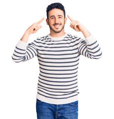 Young hispanic man wearing casual clothes smiling pointing to head with both hands finger, great idea or thought, good memory