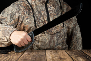 Machete in the hands of a man. A tool for survival in the forest. - obrazy, fototapety, plakaty