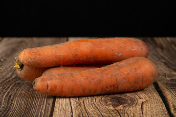 Carrots are red on a dark background. Sale of fresh carrots.