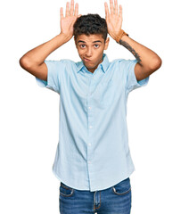 Young handsome african american man wearing casual clothes doing bunny ears gesture with hands palms looking cynical and skeptical. easter rabbit concept.