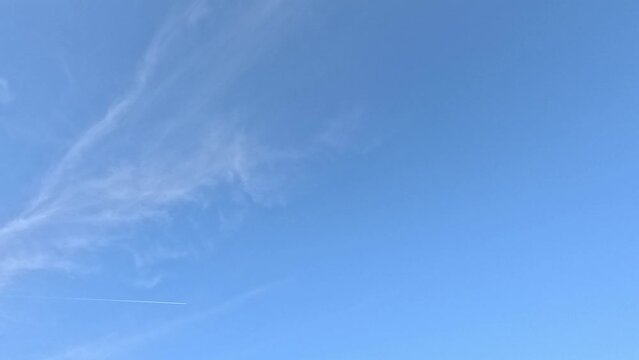 Time lapse of a cloud being blown by the wind against the blue white silky sky
