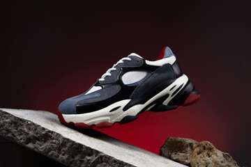 Modern sneakers for travelling and walking. Casual shoe on podium like rocky mountain peak. Shoes...