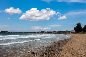 Summer holiday, sandy beach, ripple sea water, nature, people, swim, relaxation, sunbathe in Greece.