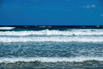 Greece, ripple dark sea water, splashing foam, Greek blue sky background, copy space. Ad template