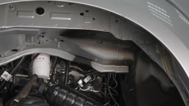 The master sprays an anti-corrosion compound on the bottom of the car. 