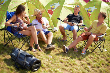 Camping, group of friends in conversation at tent and relax with outdoor chat, drinks and grass....