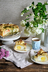 a piece of Pie with whole boiled eggs, salmon, cheese, chives. White background.
