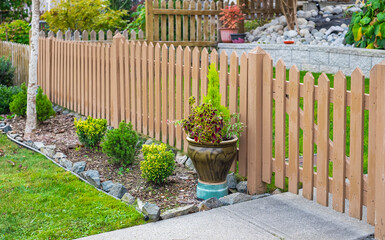 Nice wooden fence around house. Wooden fence with green lawn. Entrance gate. Street photo