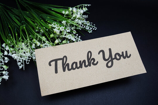 Thank you text message with flower decoration on black background