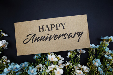 Happy Anniversary text message with flower decoration on black background