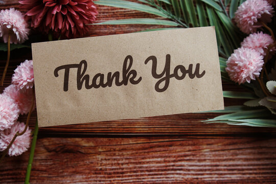 Thank you text message with flower decoration on wooden background
