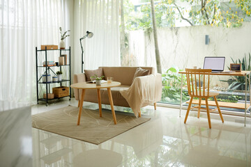 Light spacious living room area with couch, coffee table, and desk for work