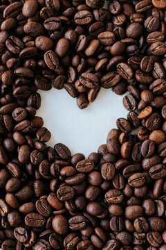 coffee beans all over the background, in the center there is a heart made of emptiness