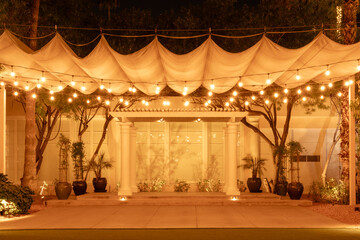 stage with string lights and canopy at night. Wedding ceremony or event stage with copy space