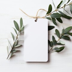 white blank tag with blank front realistic on a mockup template in a white wooden table with olive leaf branch