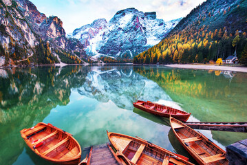 Magical autumn landscape with boats on the lake on Fanes-Sennes-Braies in the Dolomites Alps, Italy. (mental vacation, holiday, inner peace, harmony - concept) - obrazy, fototapety, plakaty