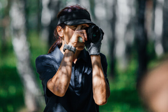 Female golfer looks into rangefinder and measures distance