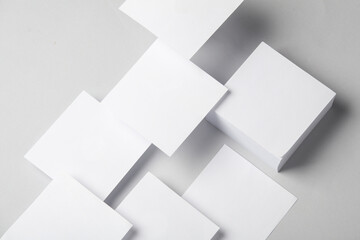 Fototapeta na wymiar Composition of floating white square memo papers on gray background. Business concept