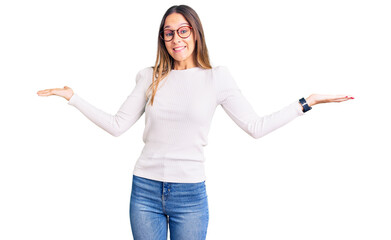 Beautiful brunette young woman wearing casual white sweater and glasses clueless and confused...
