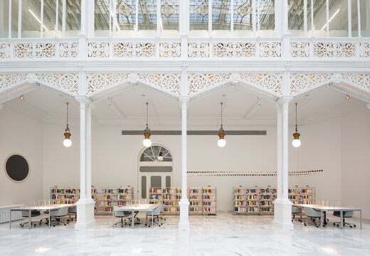 Books with tables and chairs in white library
