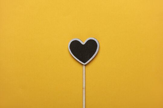 Chalkboard label, blank wooden blackboard tag, heart shaped garden sign on yellow background - Powered by Adobe