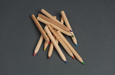 Set of wooden colored pencils on dark gray background. Creativity, art