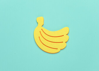Handmade felt banana on a blue background