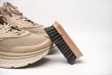 Sneakers with Shoe brush on white background. Footwear care