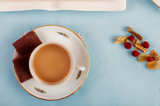 Elegant teacup with snacks on a vibrant blue backdrop