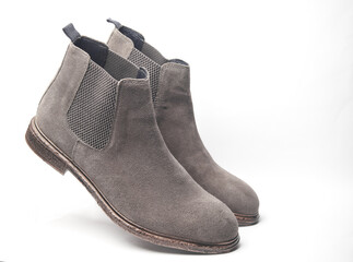 Floating gray suede Chelsea boots on white background