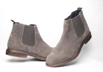 Floating gray suede Chelsea boots on white background