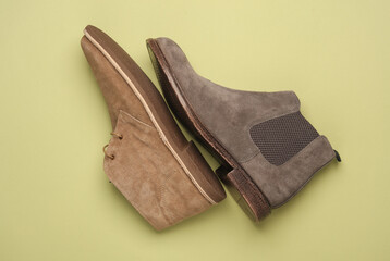 Suede desert and Chelsea boots on green background