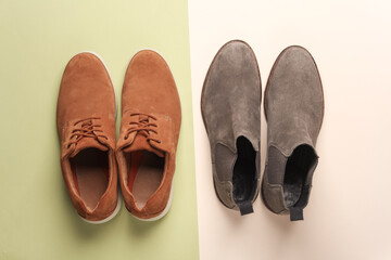 Two pairs of suede men's shoes on a green beige background. Top view