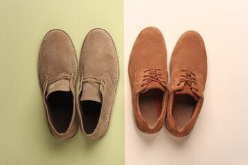 Two pairs of suede men's shoes on a green beige background. Top view