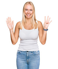 Young blonde girl wearing casual style with sleeveless shirt showing and pointing up with fingers...