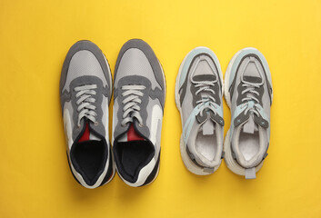 Male and female pair of sports shoes for running on a yellow background