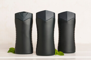 Men cosmetic bottles with mint leaves on table