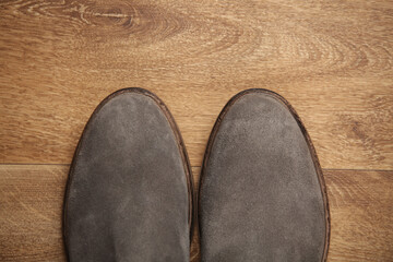 Pair of gray suede Chelsea boots on the floor. Top view